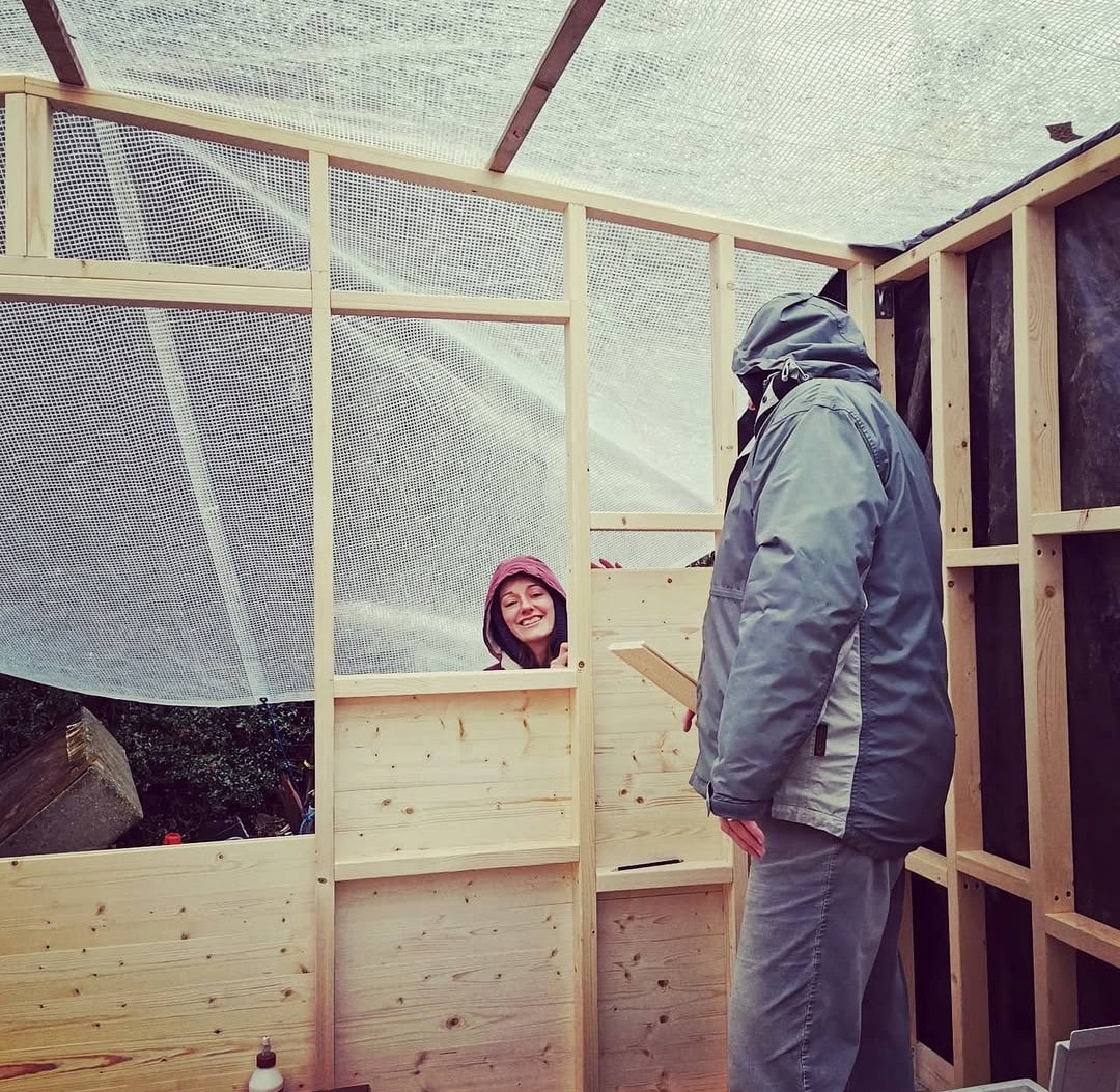 Family members inside the partially built Shack structure