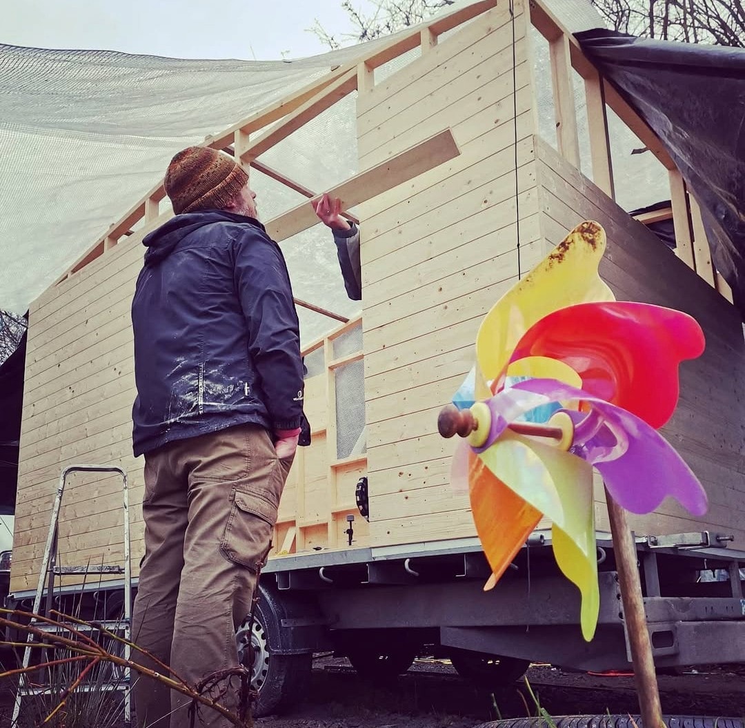 Building the wooden exterior of The Shack with a colourful pinwheel in front