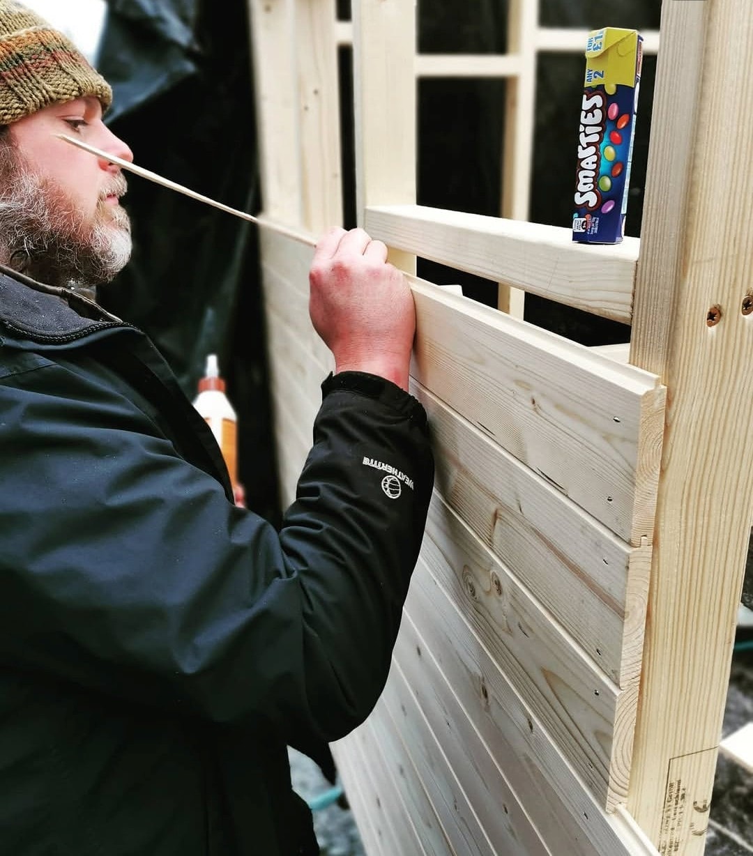 Carefully measuring and fitting timber cladding by hand
